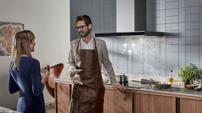 Twee mensen staan gezellig in de keuken bij een Electrolux kookplaat en afzuigkap