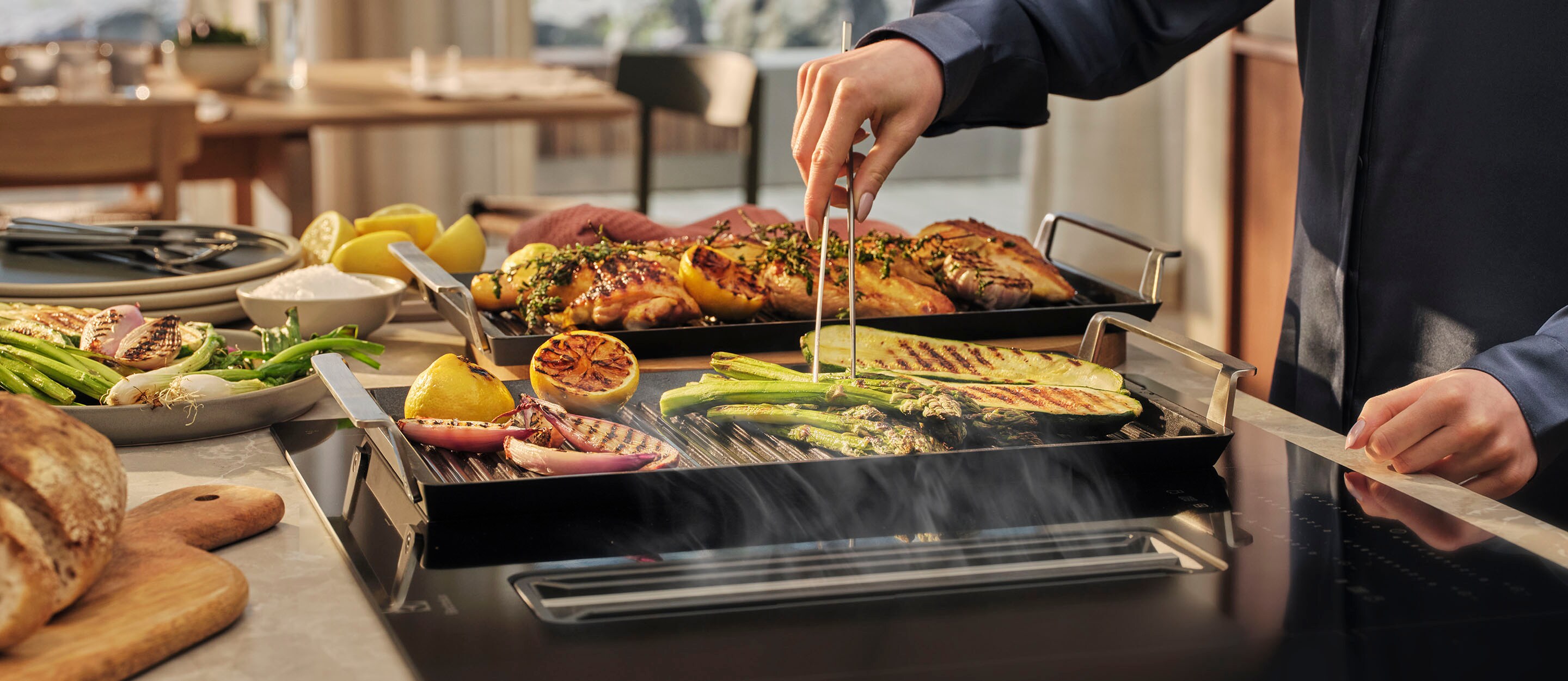 Iemand is groenten aan het grillen op een plancha grill die staat op een inductiekookplaat
